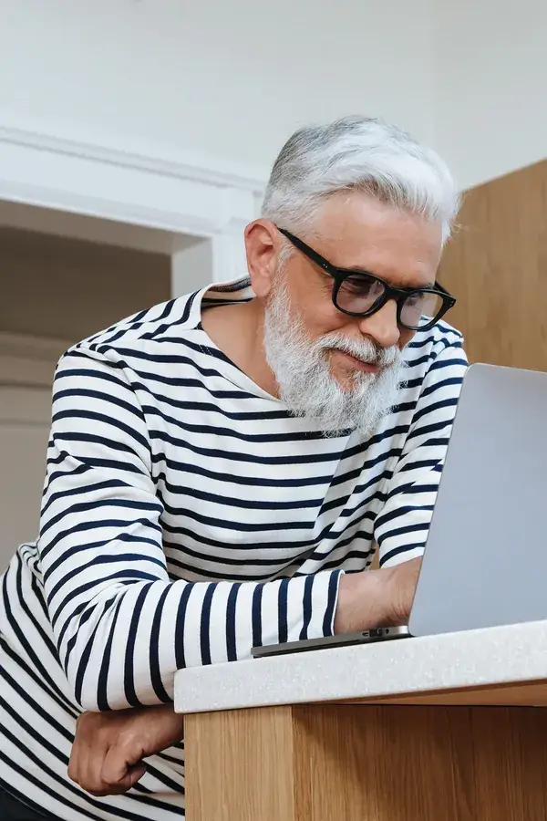Man med glasögon som arbetar vid en laptop